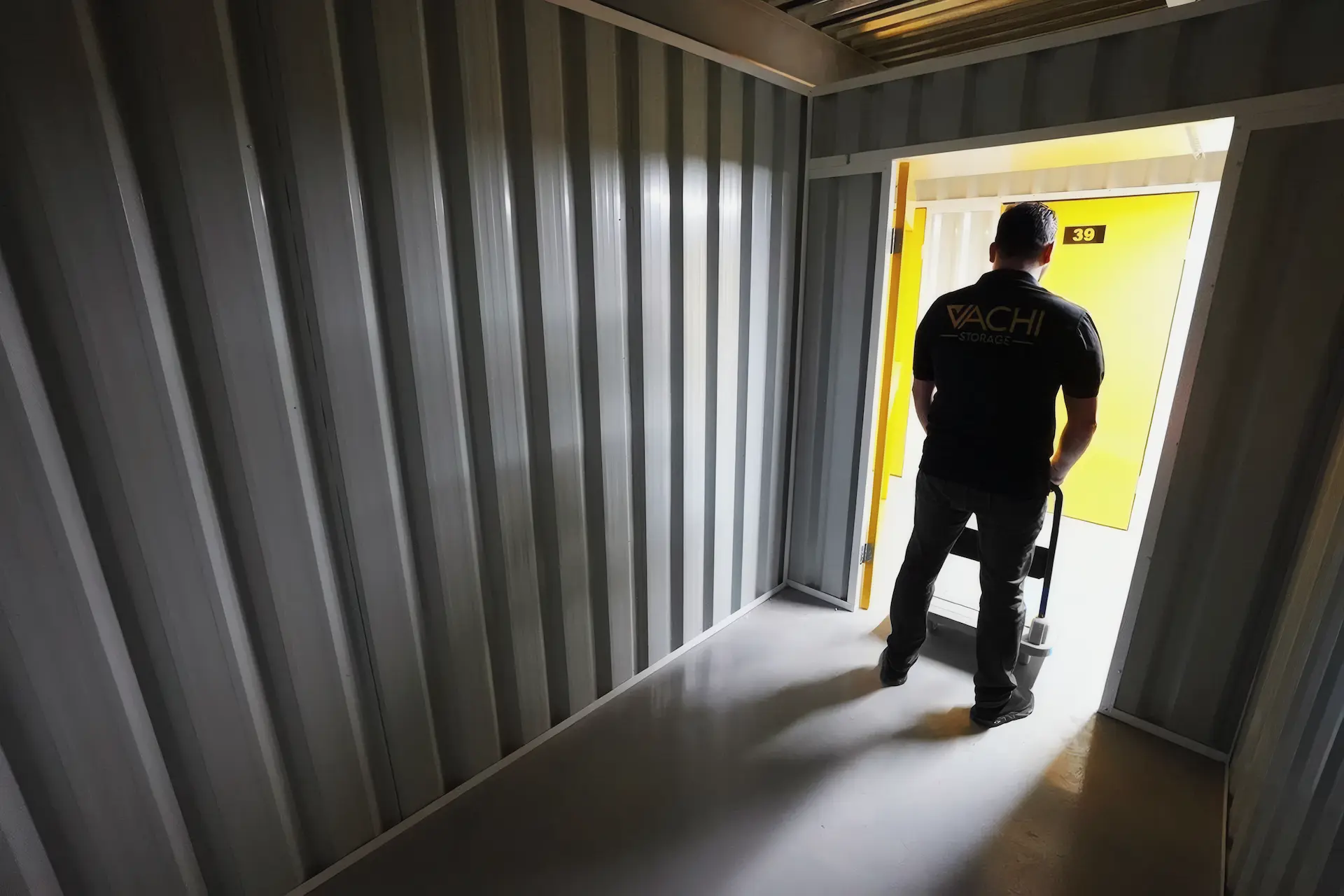 A Vachi team member wheeling a trolley out of an open walk-in storage room